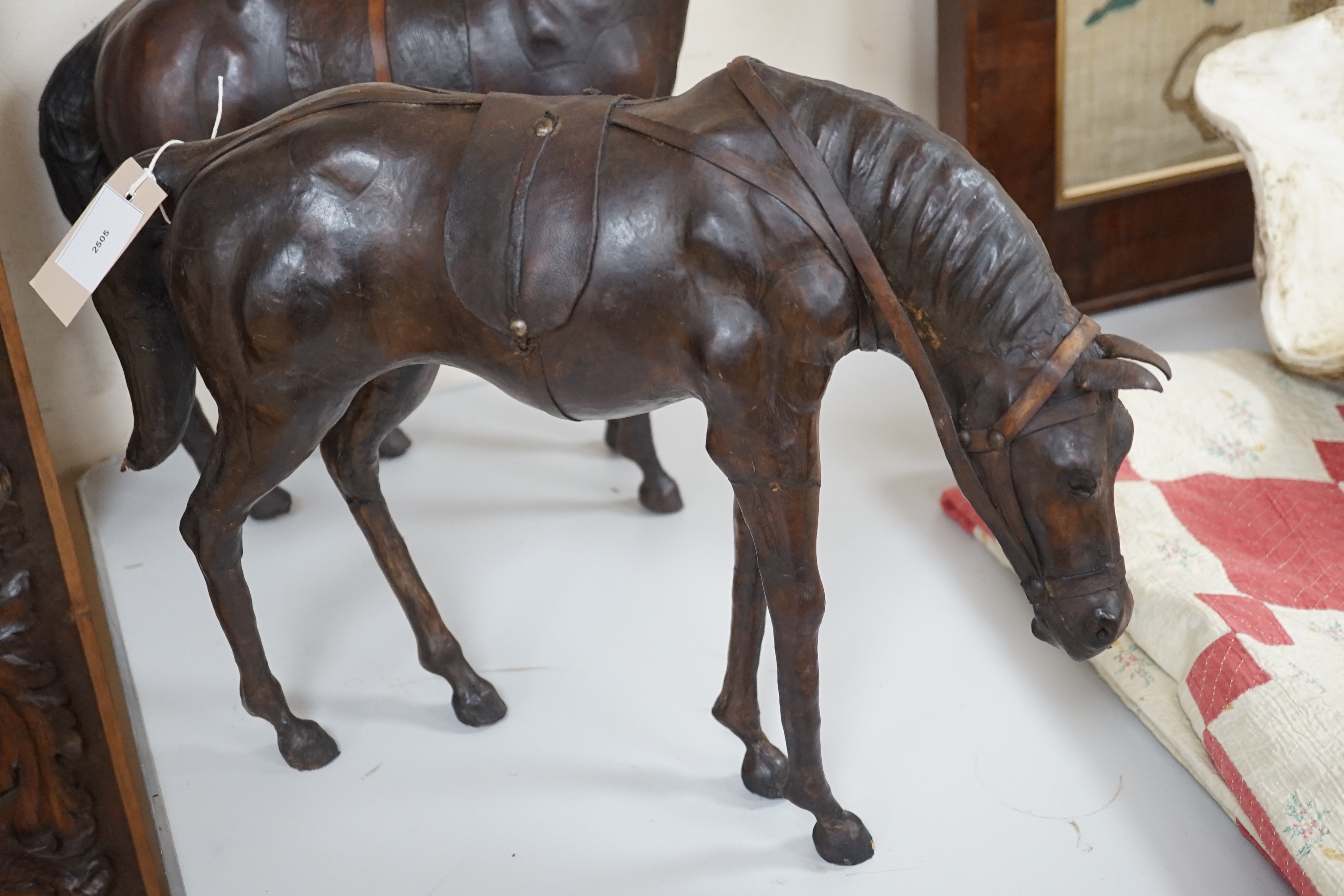 Two finely modelled horses made from brown leather, tallest 49 cms high